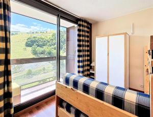 a living room with a couch and a large window at Résidence Pegase - APPARTEMENT 3 PIECES 7 PERSONNES PISTES MAE-9854 in Le Corbier