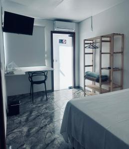 a room with a bed and a table and a chair at FRAN's - HOSPEDAGENS in Lagoa Santa