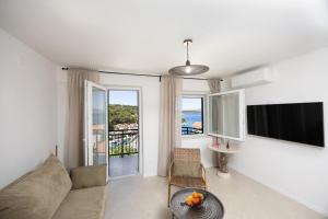 a living room with a couch and a tv at Rosa in Povlja