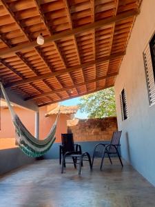 un porche avec deux chaises et un hamac dans l'établissement Casa de Temporada WK, à Campo Alegre