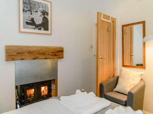 a room with a fireplace and a bed and a chair at 1 bed in Newport 86258 in Blackwater