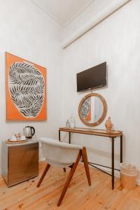 ナフプリオにあるArsenale di Nafplio Roomsのデスク、椅子、鏡が備わる客室です。