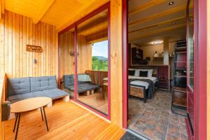 ein Zimmer mit Couch und Bett und ein Schlafzimmer in der Unterkunft Wezly Tiny House in Măgura