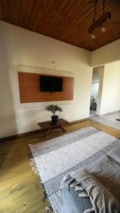 a living room with a flat screen tv on a wall at Chalé Encanto da Serra in São Francisco Xavier
