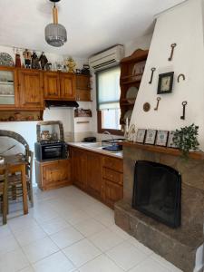 a kitchen with a fireplace in the middle of it at Vigliata Sidirounta Traditional Stonehouse in Chios