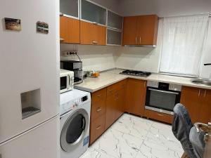 a kitchen with a washing machine and a microwave at Cozyhouse in Drobeta-Turnu Severin