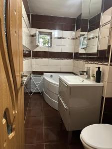a bathroom with a toilet and a tub and a sink at Cozyhouse in Drobeta-Turnu Severin