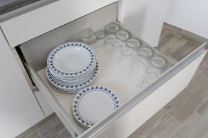 a cabinet with two plates and glasses in it at Apartamentos Áurea Casas del Sur in La Puebla de Cazalla +220 photos
