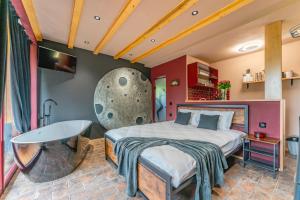 a bedroom with a large bed and a table at Wezly Tiny House in Măgura