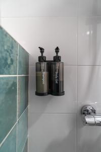 two bottles on a shelf on a bathroom wall at Apartamentos Áurea Casas del Sur in La Puebla de Cazalla