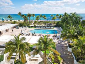 an aerial view of a resort with a pool and the ocean at Seacoast Suites on Miami Beach in Miami Beach