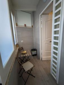 a hallway with a table and a chair and a door at Al GeChiGiù in Bacoli +12 photos