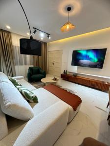 a living room with two couches and a flat screen tv at La brise Marine in Lomé