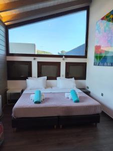 a bedroom with a bed with a large window at Schinias beach villa in Schinias