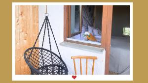 a porch with two chairs and a window at Berghupferl-Alm mit Wellnessoase im Garten in Flintsbach am Inn