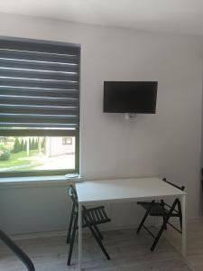 a room with a desk and a tv and a window at Apartament w Kocierzu in Kocierz Rychwałdzki +7 photos