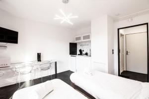 ein weißes Zimmer mit einem Bett, einem Tisch und Stühlen in der Unterkunft Sweet-Thermal Amnéville loisir, parking gratuit in Amnéville