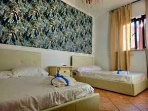 two beds in a room with a mural on the wall at Il Bacio di Roma in Infernetto