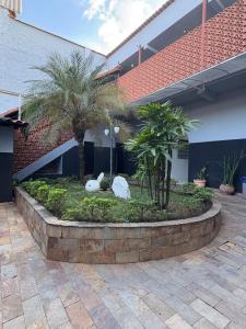 ein Innenhof mit Palmen und zwei weißen Kaninchen in der Unterkunft Motel Fascinação in Contagem