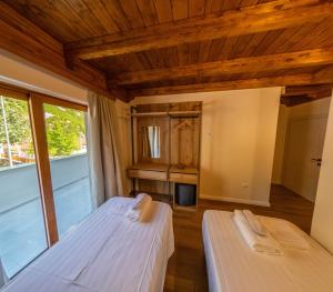 2 bedden in een kamer met houten plafonds bij Sofra Kelmendit in Tamarë