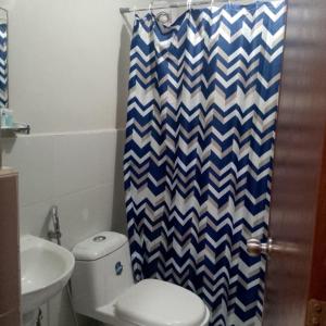 a bathroom with a toilet and a shower curtain at Belle Place at Saekyung Marigondon Building 203 unit 1303 in Lapu Lapu City