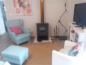 a living room with a blue chair and a tv at Casas de Alegrete - Castelo by Portus Alacer in Alegrete +64 photos