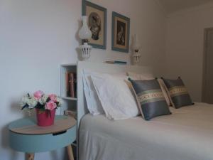a bedroom with a bed and a table with flowers on it at Casas de Alegrete - Castelo by Portus Alacer in Alegrete