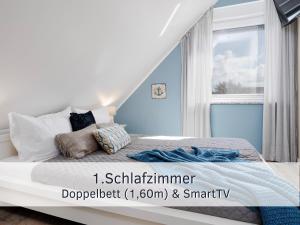 une chambre avec un lit aux murs bleus et une fenêtre dans l'établissement Lotsenbude Fehmarn, perfekt für Familien & Paare, Nähe Hafen Burgstaaken, à Burg