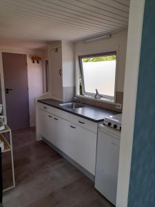 a kitchen with a sink and a window at Chalet B2 in Westergeest
