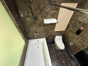 a bathroom with a tub and a toilet in it at Suasana Hotel Chukai in Cukai