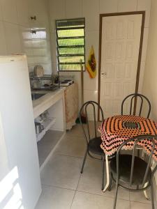 a kitchen with a table and chairs and a sink at Cantinho da Paz in Miguel Pereira