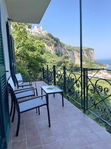 a balcony with two chairs and a table with a view at Seventy Steps in Vico Equense