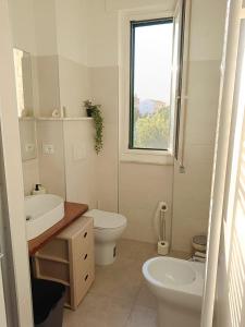 a bathroom with a sink and a toilet and a window at Casa Verina at the station in Castiglion Fiorentino +17 photos