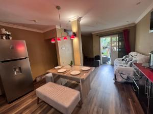 cocina y sala de estar con mesa y nevera en B&B Pereybere Mauritius, en Pereybere