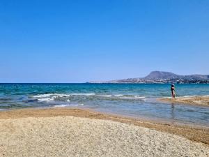 a person standing in the water on a beach at Hidden Gem at Kiani Beach in Kalyves +5 photos