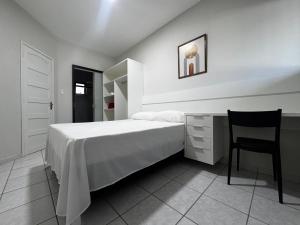 a bedroom with a bed with a chair and a desk at Duplex Central TAVARES ARAUJO in Garanhuns