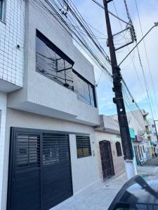 a building with black garage doors on a street at Duplex Central TAVARES ARAUJO in Garanhuns