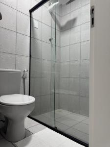 a bathroom with a toilet and a glass shower at Duplex Central TAVARES ARAUJO in Garanhuns +31 photos