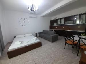 a bedroom with a bed and a couch and a clock at Albert Guest House in Borsh