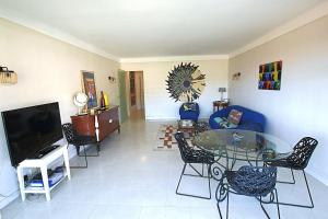 a living room with a blue couch and a glass table at Fully equipped appartment 105 m2 clear view on the sea and californie hills in Cannes