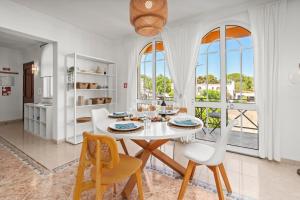 a white dining room with a white table and chairs at Elegant Flat with Pool & Balcony by HostWise in Tavira