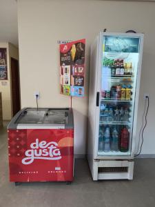a cocacola refrigerator with its door open and a drink cooler at Pousada Donna Maraka in Porto De Galinhas