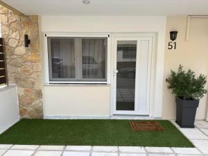 a front door of a house with a plant at Nostos in Nea Moudania