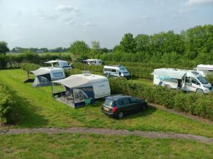 a group of tents and vehicles parked in a field at Camping de Haarakker in Langeveen