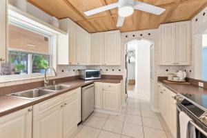 a kitchen with white cabinets and a sink at Beach Breeze House in Fort Pierce