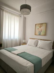 a bedroom with a large white bed with a green blanket at Deppy's House in Vasiliki