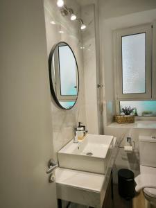 a white bathroom with a sink and a mirror at Deppy's House in Vasiliki +50 photos