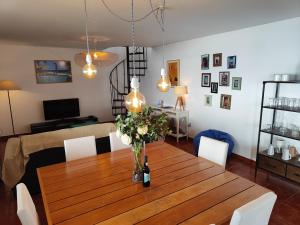 ein Esstisch mit einer Vase mit Blumen darauf in der Unterkunft Casa da Ovelha I Madeira in Fajã da Ovelha