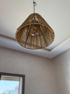 a rattan light hanging from a ceiling at célestia in Sidi Ifni +8 photos