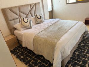 a bedroom with a large white bed with two pillows at célestia in Sidi Ifni